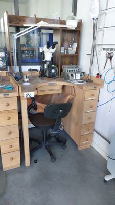a desk with a computer and a chair in a room