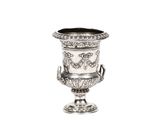 un vase en argent posé sur une surface blanche