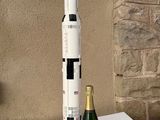 une maquette de fusée et une bouteille de champagne posées sur une table