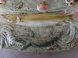 a fish on a platter with shells on it