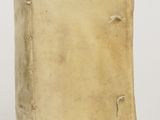 an old book sitting on top of a white table next to a white wall