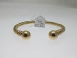 un gros plan d'un bracelet en or orné de deux boules