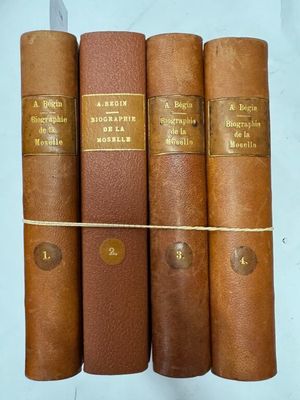 quatre livres sont alignés sur une surface blanche