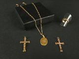 trois croix en or et un pendentif en forme de croix sur un fond noir