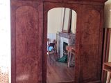 a mirror in the corner of a room with a wooden cabinet