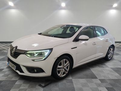 une voiture blanche garée dans une pièce au sol en damier