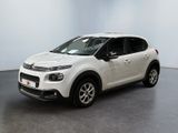 Une Citroën blanche est garée dans une pièce blanche
