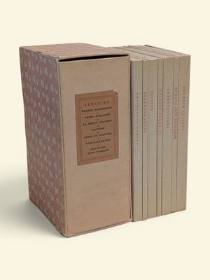 trois livres dans une boîte en carton posée sur une surface blanche