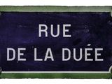 blue and white street sign with the words rue de la duee written on it