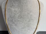 un collier à chaîne en or sur un mannequin mannequin mannequin mannequin mannequin mannequin mannequin mannequin mannequin mannequin