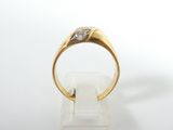 a close up of a gold ring with a diamond on it