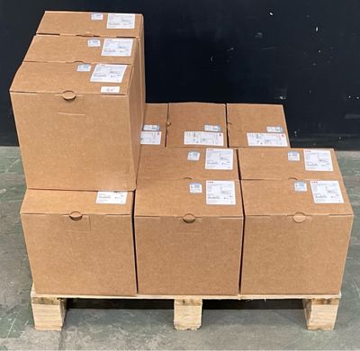 several boxes are stacked on a pallet in front of a black wall