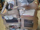 une grande pile de vêtements posée sur une palette dans un entrepôt