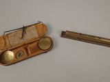 une petite boîte en bois contenant un objet en métal