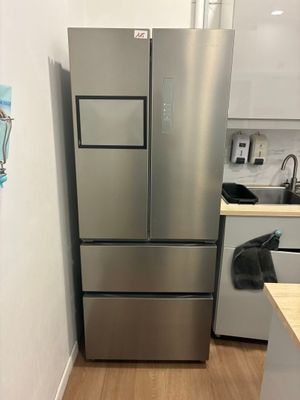 un réfrigérateur en acier inoxydable dans une cuisine au sol en bois
