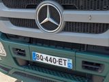 a mercedes truck parked in a parking lot next to a building