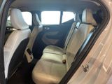 the back seats of a white car are empty in the room