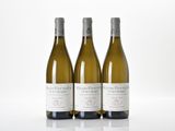 three bottles of white wine sitting next to each other on a table