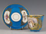 une image représentant une tasse et une soucoupe bleues posées à côté d'une assiette