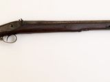 un gros plan d'un fusil accroché au mur sur un fond blanc