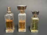 three bottles of perfume sitting next to each other on a table