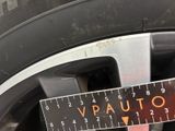 someone is measuring the width of a tire with a ruler