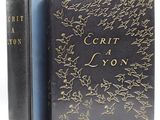 un livre noir orné de lettres dorées, posé à côté d'un autre livre noir