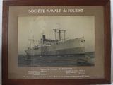 photo encadrée représentant un bateau à l'eau, sur lequel est apposée une plaque
