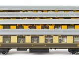 several model trains are lined up in a row on a white surface