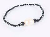 a black beaded bracelet with a white pearl and black beads