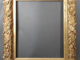 an ornate gold framed mirror with leaves and flowers