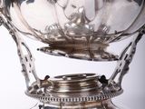 a silver bowl with a handle on a stand
