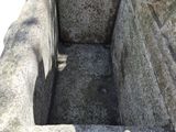 a stone sink that is sitting in the middle of a stone wall