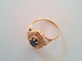 a close up of a gold ring with a black stone in it