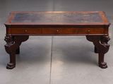 a wooden table with a glass top on a cement floor