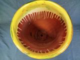 a yellow bowl with a red and yellow design on it
