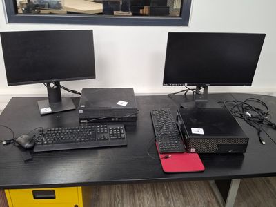 two computer monitors and a keyboard on a desk
