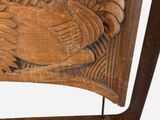 a wooden carving of a rooster on the back of a chair