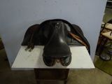 a horse saddle and a pair of shoes sitting on a table