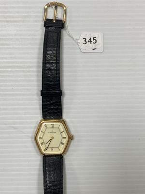 gros plan d'une montre sur une surface blanche avec une étiquette de prix