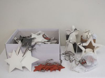 une boîte blanche remplie d'objets divers, posée sur une table blanche