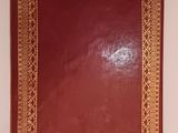 a red book with a gold border on the cover