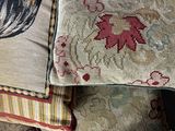 many pillows that are sitting on a bed together