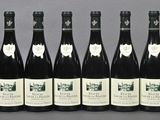 six bottles of wine are lined up in a row on a table