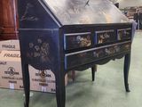 a black writing desk in a room with a lot of boxes