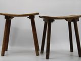 two wooden stools sitting next to each other on a white surface