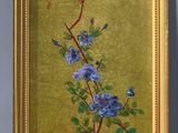 painting of a bird on a branch with blue flowers in a gold frame