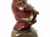 a figurine of a man sitting on top of a rock