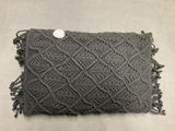 a close up of a gray pillow with a button on it