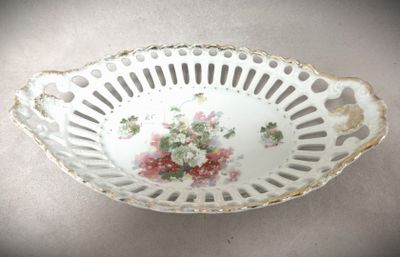 un bol blanc orné de fleurs roses, posé sur une table